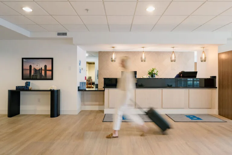 Representative hotel space: A hotel reception area with a long counter and a person pulling luggage.