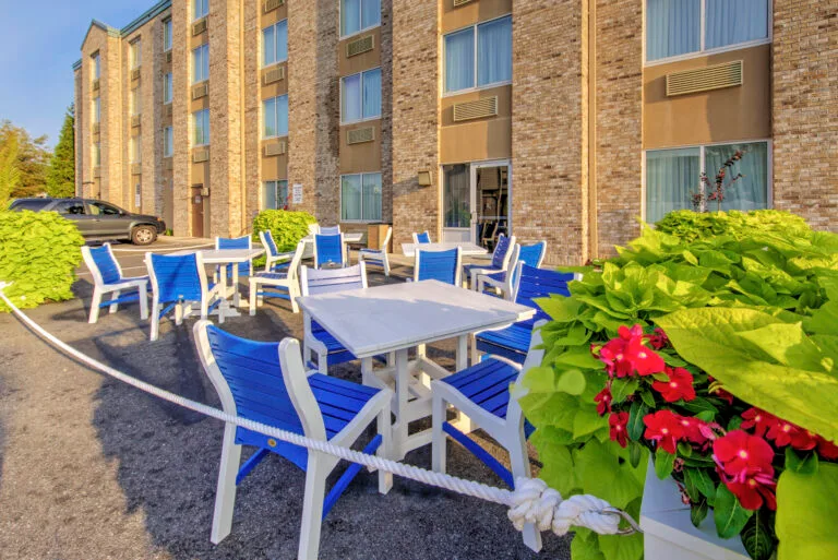 Representative hotel space: Outdoor seating area beside a brick hotel building, with tables and chairs.