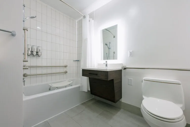 Representative hotel space: A bright bathroom with a bathtub, sink, and toilet.