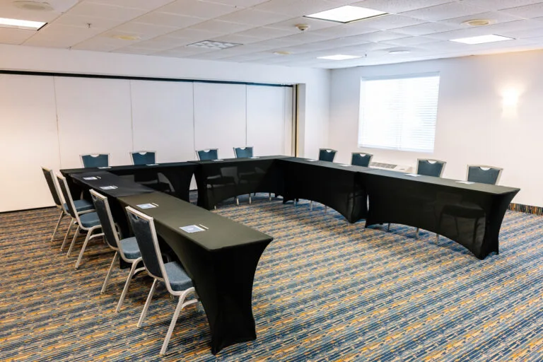 Representative hotel space: A conference room arranged with black tables and chairs.