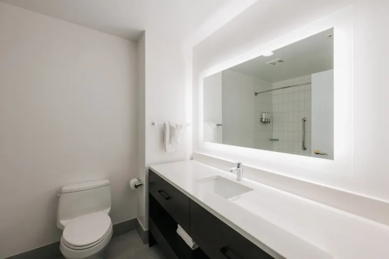 Representative hotel space: A bright bathroom with a long vanity and a large mirror.