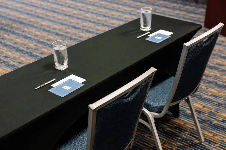 Representative hotel space: A meeting table with seating, water glasses, and notepads in a conference room.