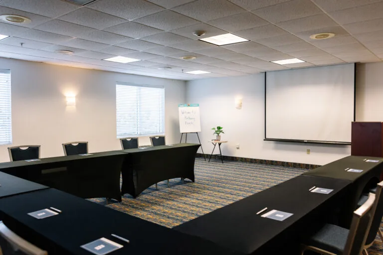 Representative hotel space: A conference room with tables arranged around the open center and a presentation screen.