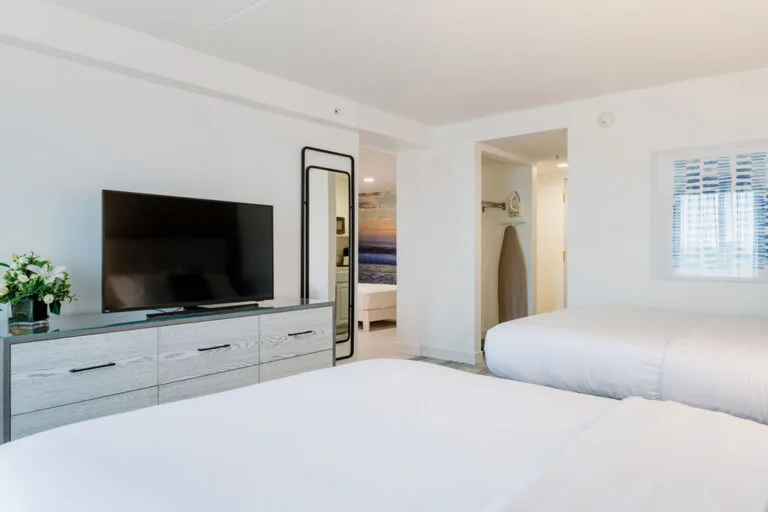 Representative hotel space: A bright bedroom with beds, a television, and a dresser.