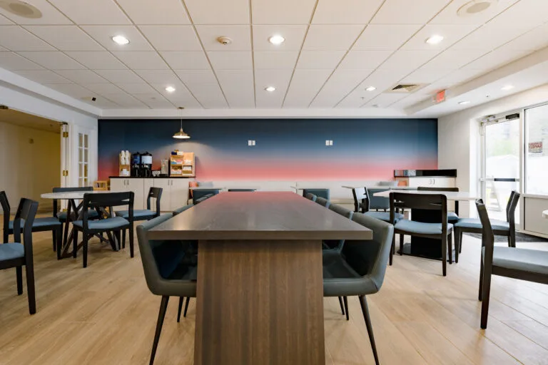 Representative hotel space: A dining area with tables and seating, with a service counter along the back wall.
