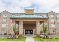 Representative hotel space: A hotel entrance with a covered walkway and landscaped flower beds.