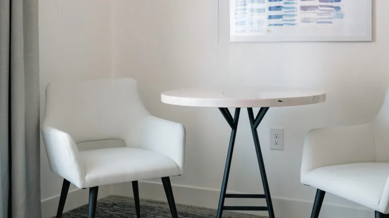 Representative hotel space: A white seating area with a round table beside a framed print.