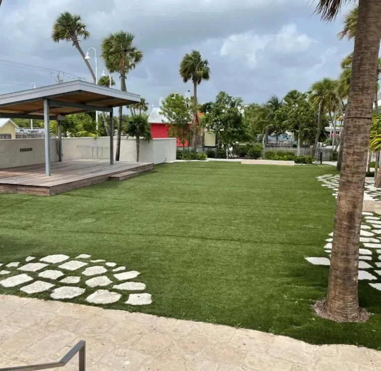 Representative hotel space: A landscaped lawn with palm trees and a covered wooden deck.