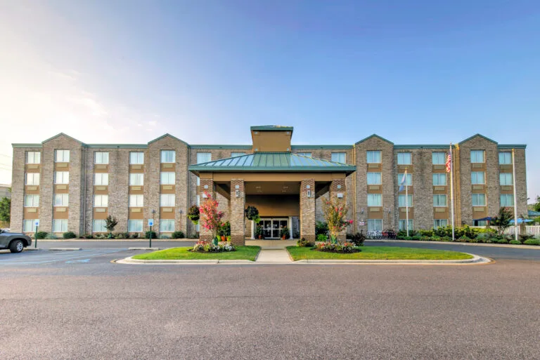 Representative hotel space: A multi-story hotel exterior with a covered entrance and landscaped grounds.