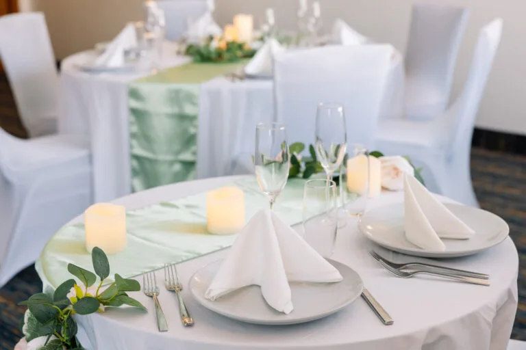 Representative hotel space: A banquet dining area with round tables set with folded napkins and candles.