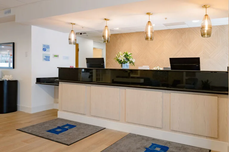 Representative hotel space: Hotel reception desk with a light wood counter and pendant lights.