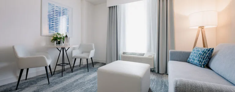 Representative hotel space: A bright hotel sitting area with a sofa, armchairs, and a floor lamp.