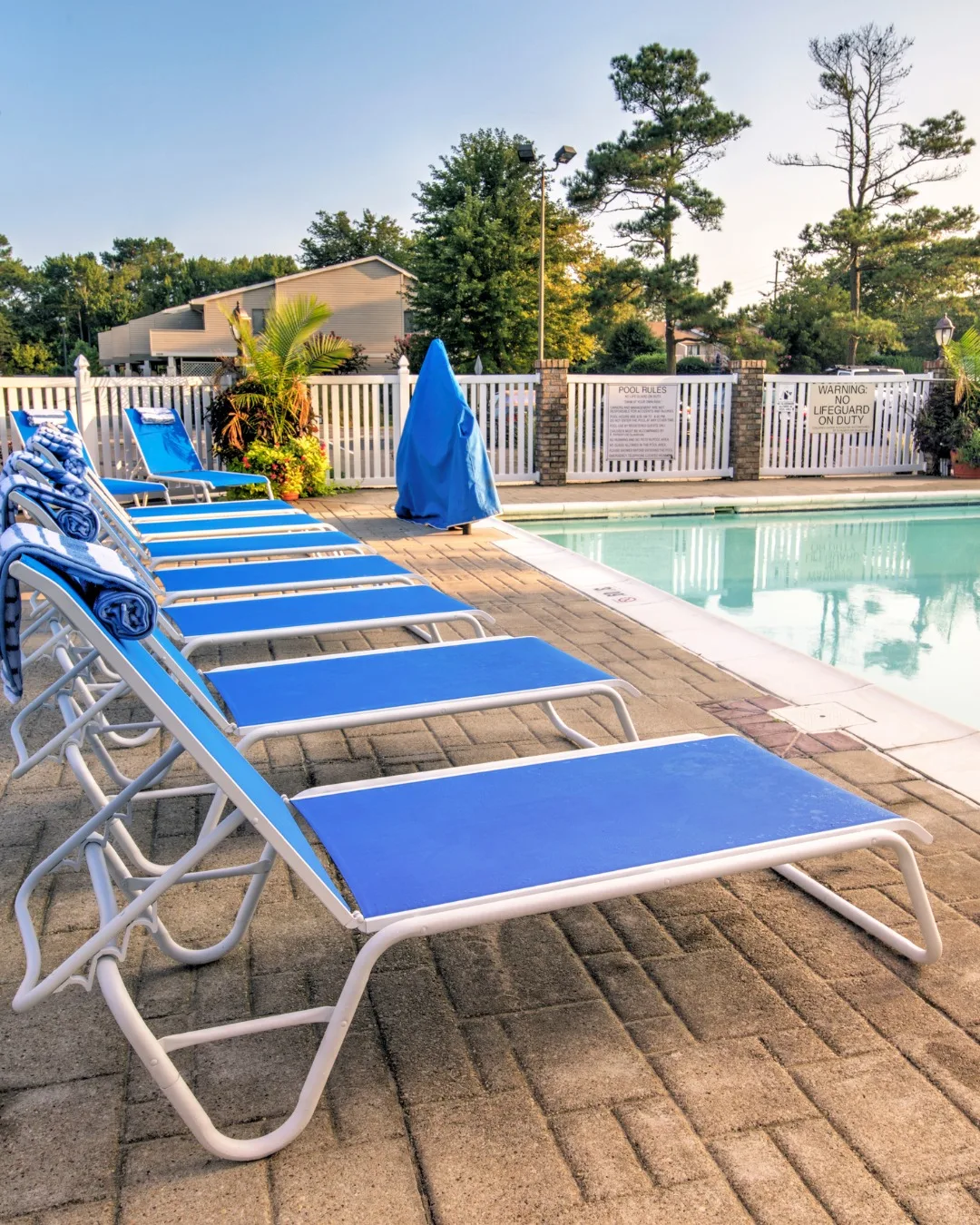 Representative hotel space: A swimming pool with blue loungers along the paved deck.