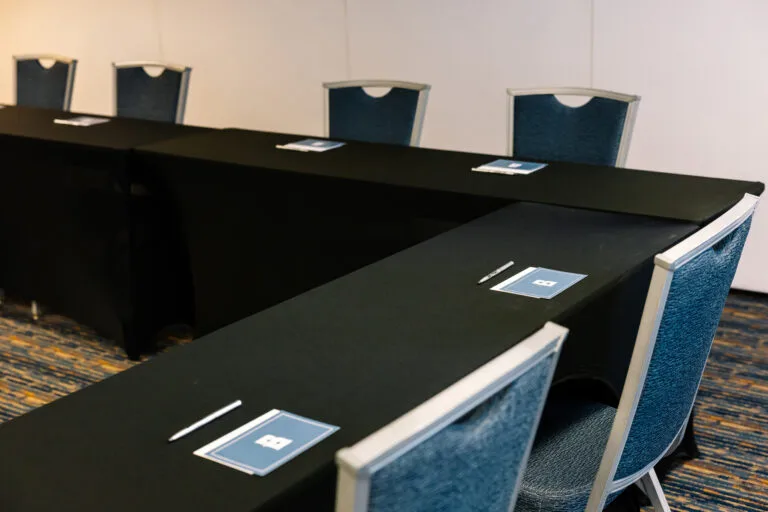 Representative hotel space: A conference room with a U-shaped table and blue upholstered chairs.