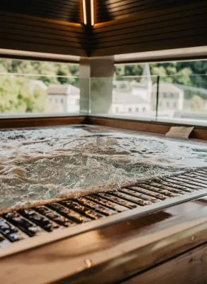 Representative hotel space: A bubbling hot tub sits beside broad windows overlooking greenery.