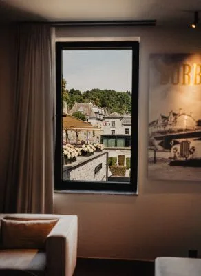 Representative hotel space: A seating area by a large window overlooking nearby buildings and greenery.