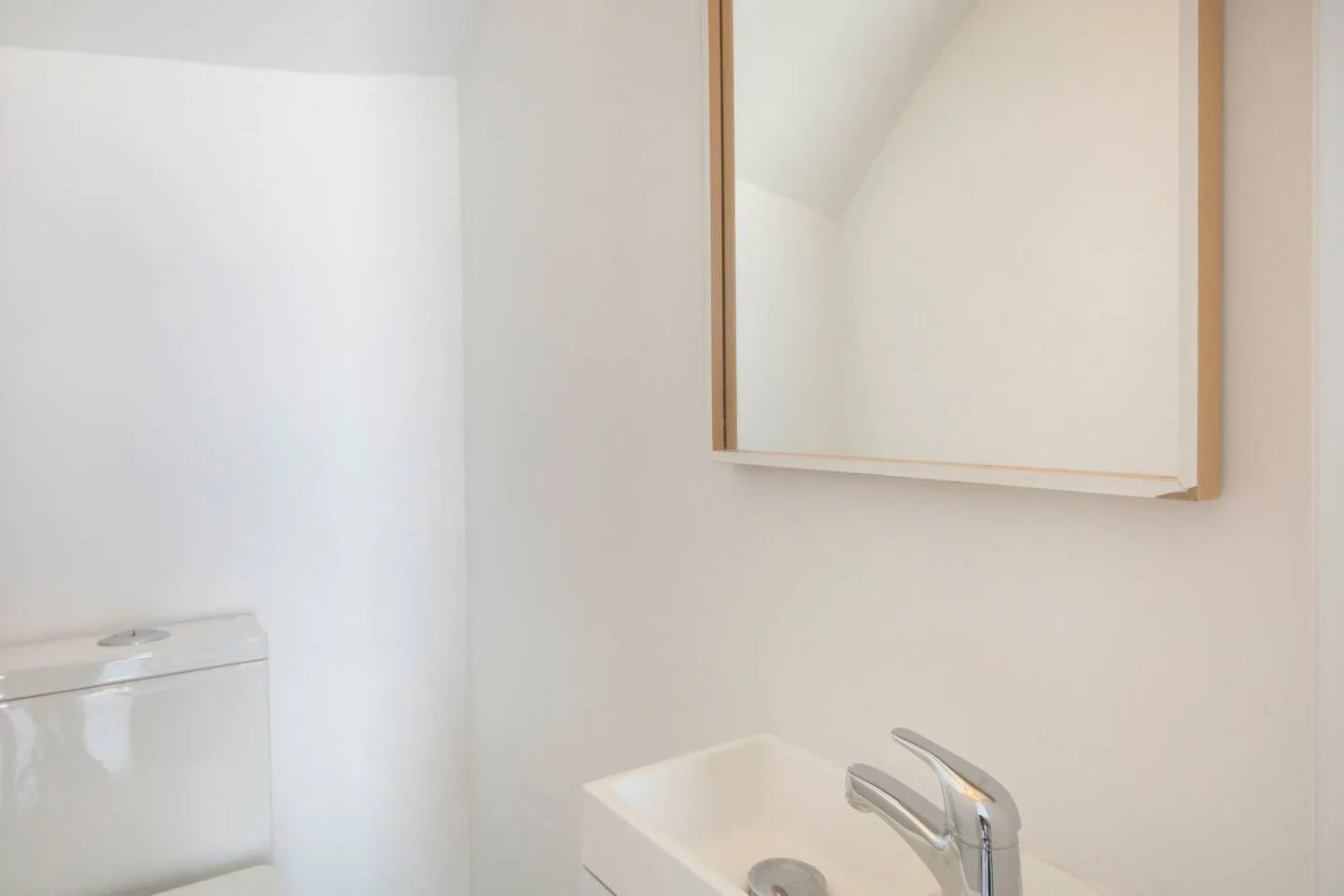 A bathroom vanity with a sink, faucet, and wall mirror.
