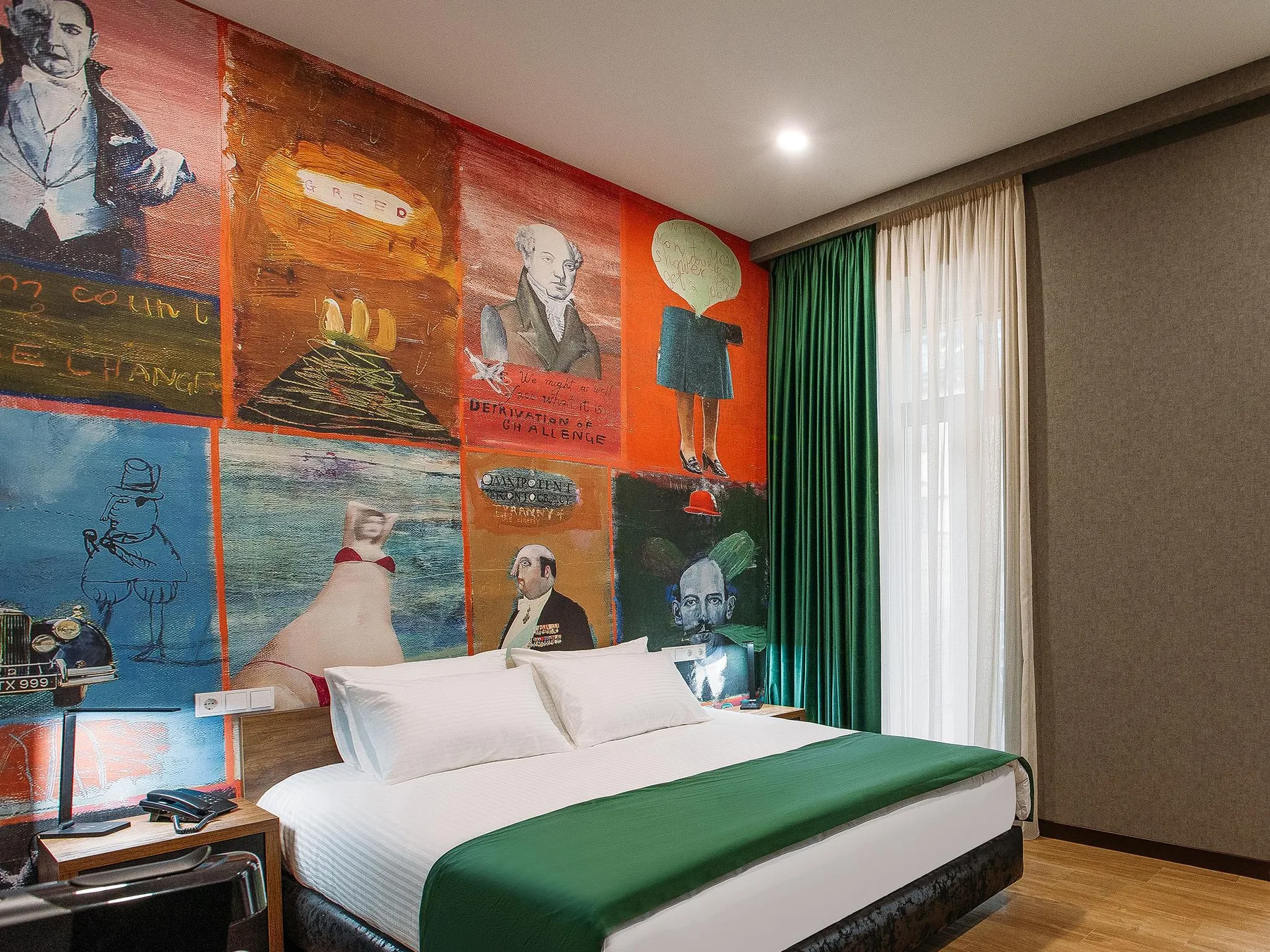 Espacio representativo del hotel: Dormitorio con una cama blanca, ropa de cama verde y paneles de mural coloridos.