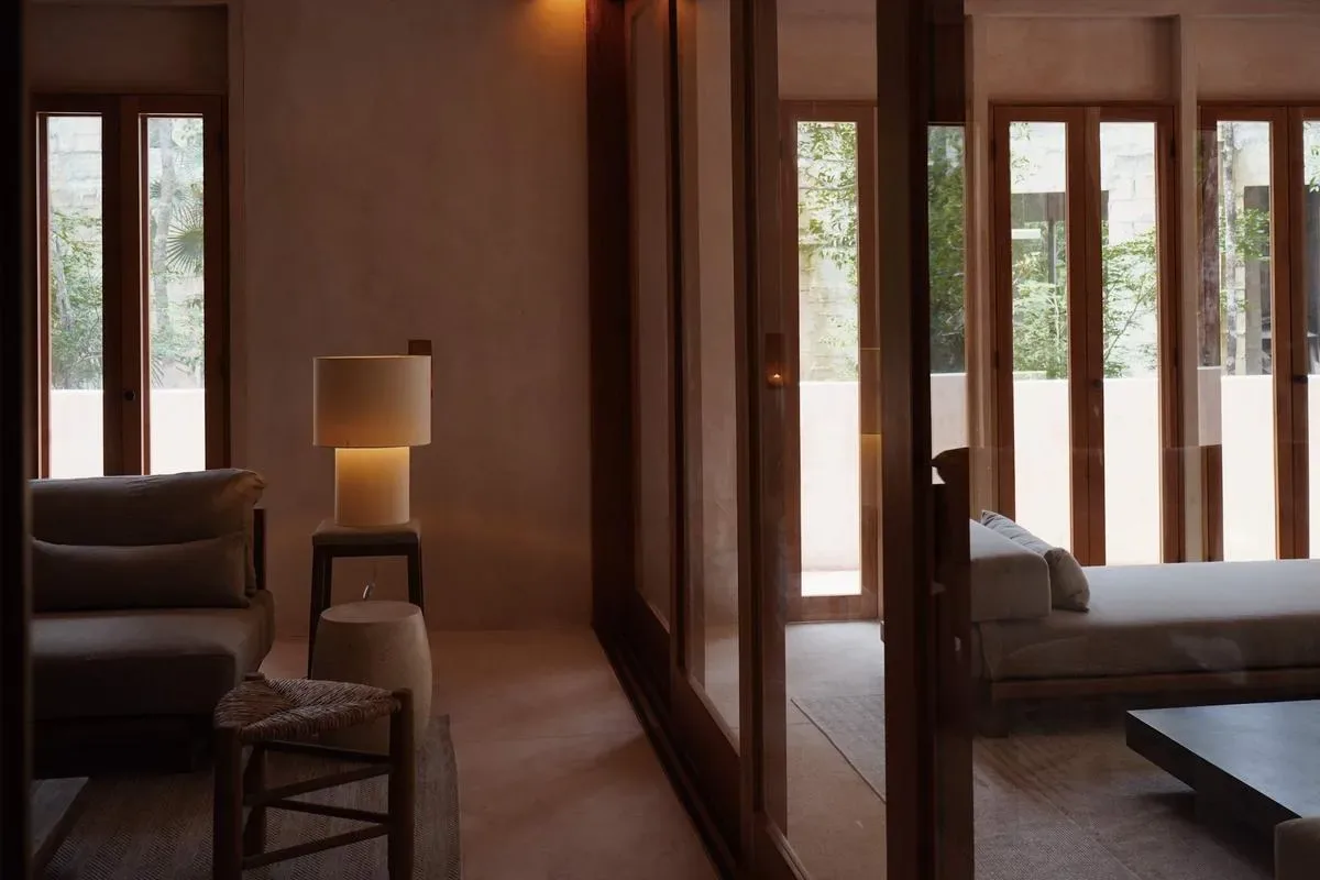 A living area with seating and a floor lamp beside glass doors.