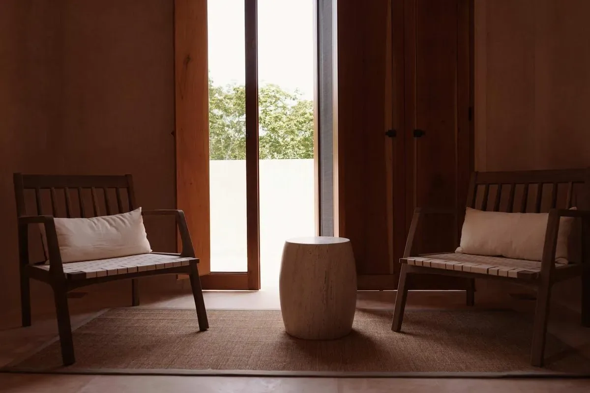 A wood-paneled sitting area with two wooden seats and a small table.