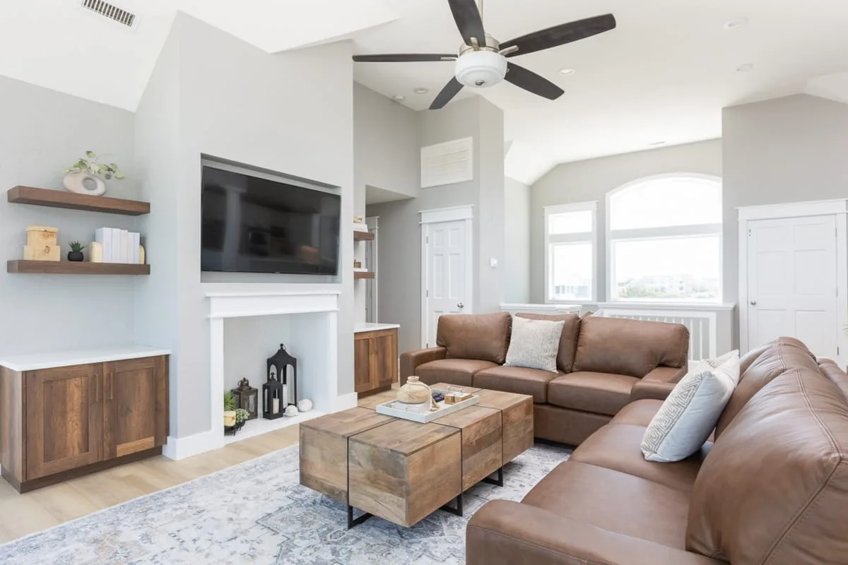 A living room with brown seating, a television, and a coffee table.