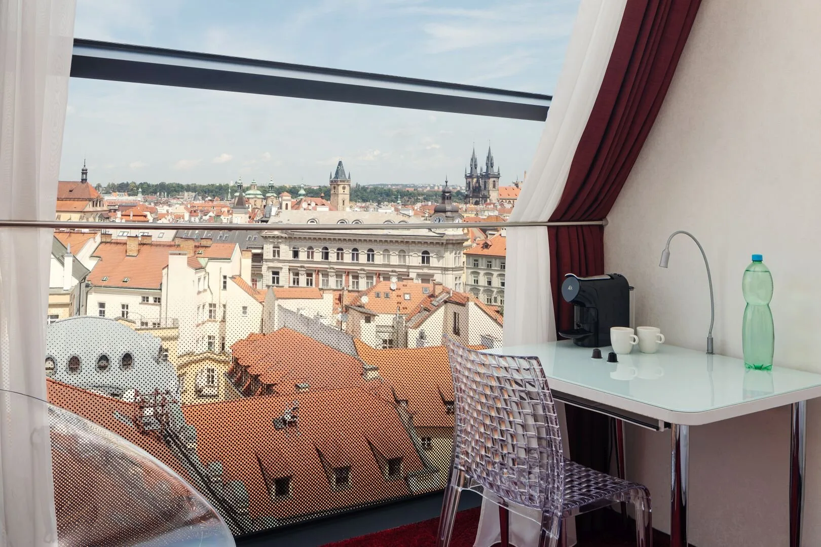 Espacio representativo del hotel: Una habitación en la azotea con escritorio y vistas a edificios históricos de la ciudad.