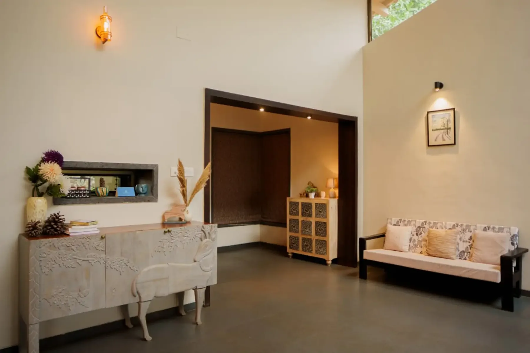 A bright interior sitting area with a decorative console and a cushioned bench.