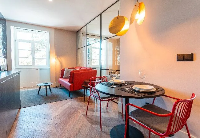 A combined living and dining area with red seating and a set table.
