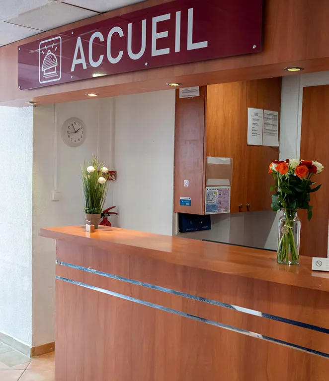 Espacio representativo del hotel: Una recepción de hotel con un letrero destacado de accueil y flores.