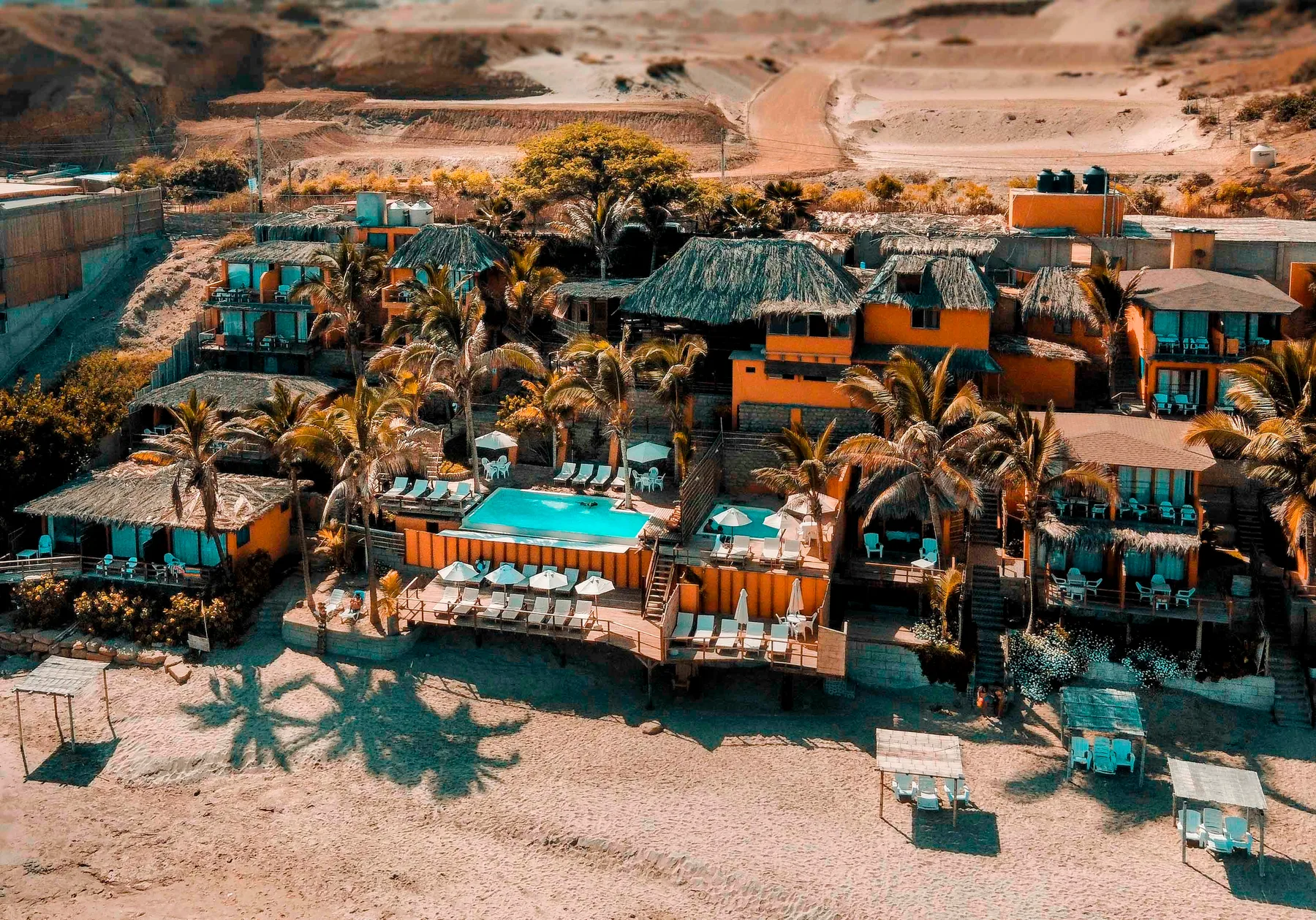 Representative hotel space: A desert resort complex with palm trees and a turquoise swimming pool.