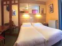 Espacio representativo del hotel: Un dormitorio de hotel con dos camas y cuadros en las paredes.