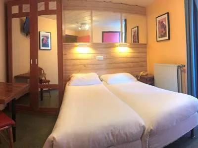 Espacio representativo del hotel: Un dormitorio de hotel con dos camas bajo un cabecero de madera.