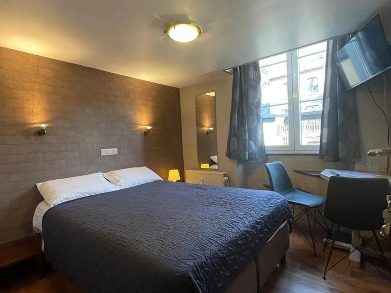 Espacio representativo del hotel: Habitación de hotel con una cama y una zona de estar junto a la ventana.