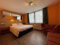 Espacio representativo del hotel: Un dormitorio de hotel con una cama, un escritorio y una ventana.