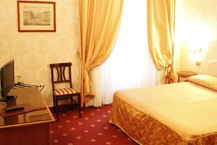 Representative hotel space: A hotel bedroom with a bed, a television, and curtained windows.