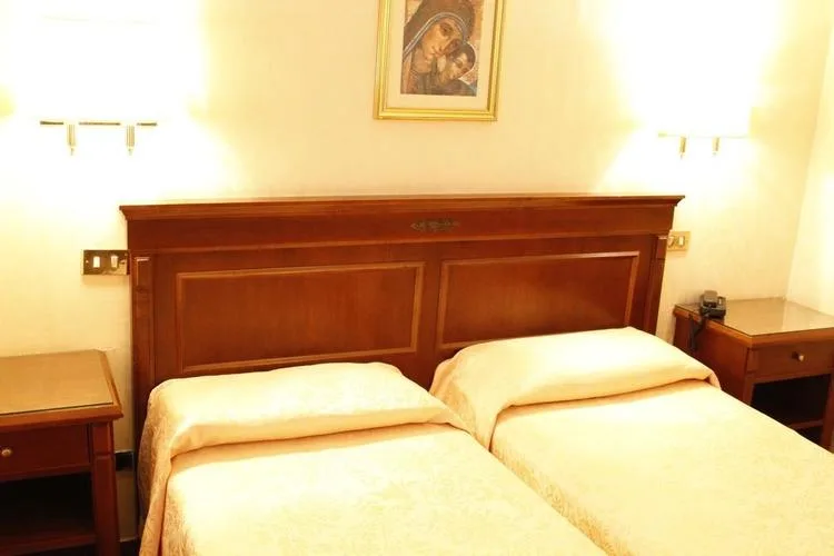 Representative hotel space: A hotel bedroom with two beds beneath a wooden headboard.