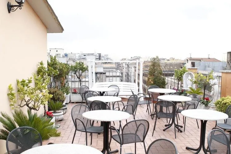 Representative hotel space: A rooftop terrace has outdoor seating and potted plants overlooking nearby buildings.