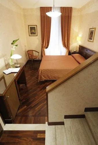 Representative hotel space: A bedroom with a double bed, a chair, and a curtained window.