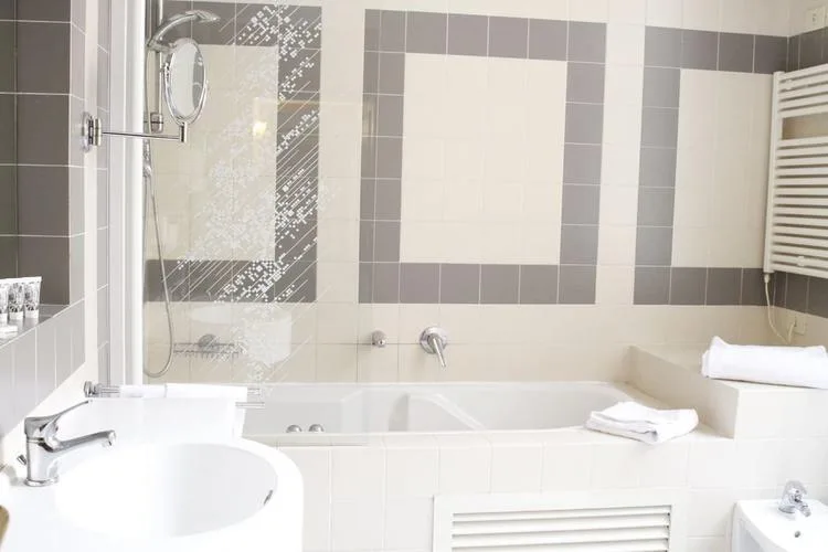 Representative hotel space: A tiled bathroom with a bathtub and sink.