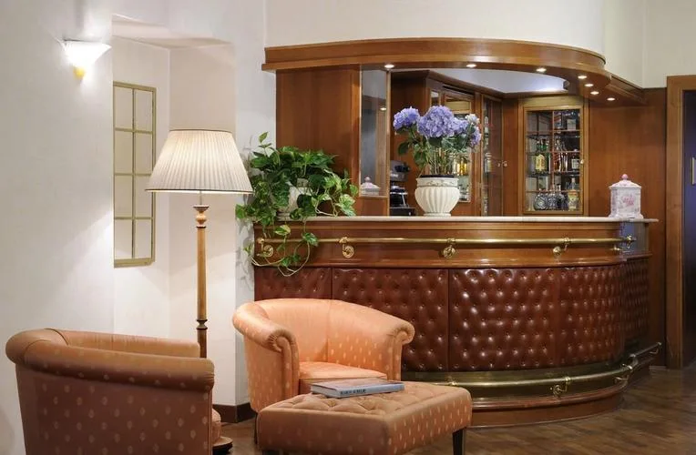 Representative hotel space: A hotel reception counter stands behind upholstered seating and a potted plant.