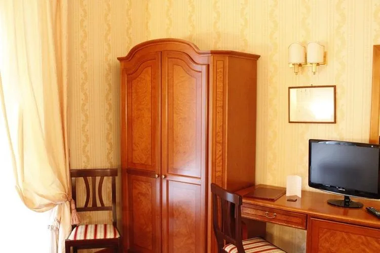 Representative hotel space: A bedroom corner with a wooden wardrobe, desk, and television.