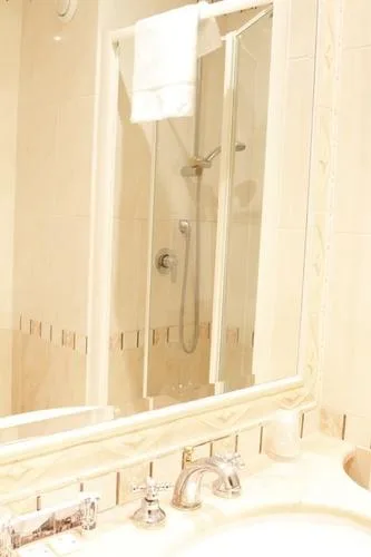 Representative hotel space: A bathroom sink and mirror are visible beside a glass shower.