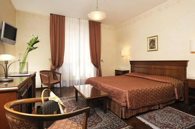 Representative hotel space: A bedroom with a large bed, a window, and a small seating area.