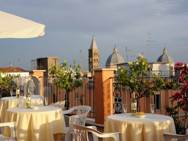 Representative hotel space: A rooftop dining terrace has round tables beneath a large umbrella.