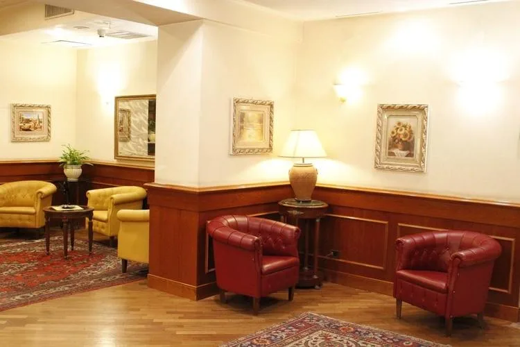 Representative hotel space: A warmly lit lounge with upholstered seating, framed artwork, and wood-paneled walls.