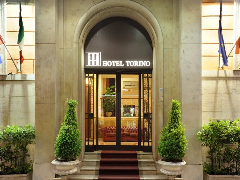 Representative hotel space: Hotel Torino’s arched entrance has glass doors and potted greenery.