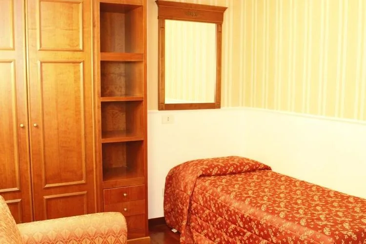 Representative hotel space: A bedroom with a bed beside built-in wooden storage.