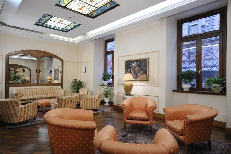 Representative hotel space: A hotel lounge with upholstered seating, framed artwork, and tall windows.