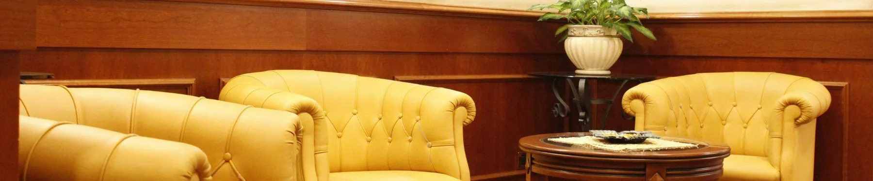 Representative hotel space: A hotel lounge with yellow upholstered seating around a small table.