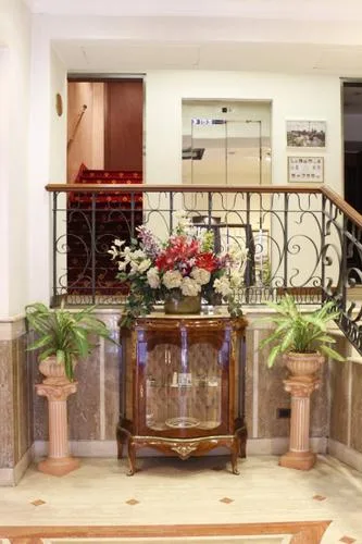 Representative hotel space: An indoor landing with a decorative railing, flowers, and potted plants.